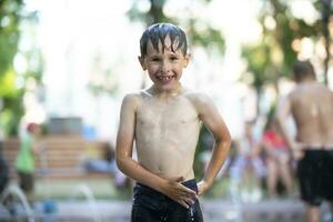 A little boy enjoys the cold waters of a fountain during the heat wave. photo