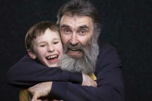 retrato de un contento abuelo con un barba y nieto en un negro antecedentes. foto