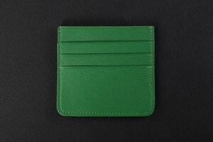 Leather products. Wallet business card holder made of green leather on a black background. photo