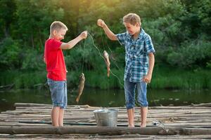 Friends boys on a fishing trip with a catch. photo