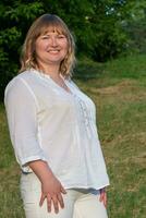 Vertical portrait of a blonde woman of middle age with a large build. photo