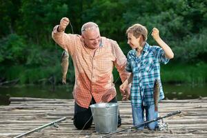 Grandfather and grandson fishing with fishing rods and fish.Summer fishing in the village. photo