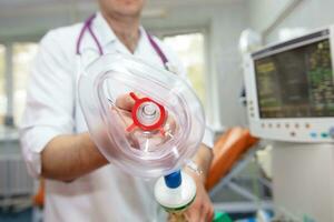 Hand of a surgeon with an oxygen mask on the background of medical devices. photo