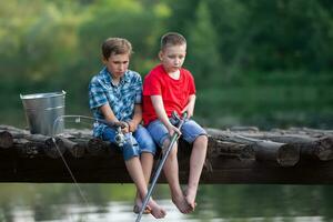 Children with fishing rods and a tense expression are fishing with fishing rods. photo