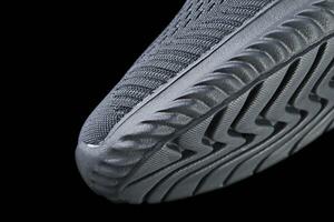 Fragment of a rubber black sole sneaker. Bottom of sports shoes photo