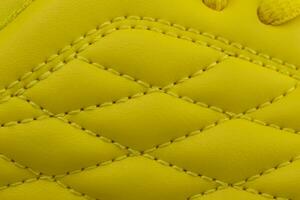 Fragment of a yellow sneaker. The texture of the material of sports shoes photo