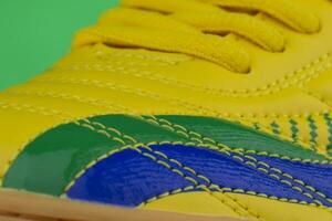 Fragment of a yellow sneaker with blue patch. The texture of the material of sports shoes photo