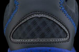 Fragment of black and blue fabric sneaker. The texture of the material of sports shoes photo