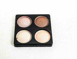 a small square box with four different colored eyeshadows photo