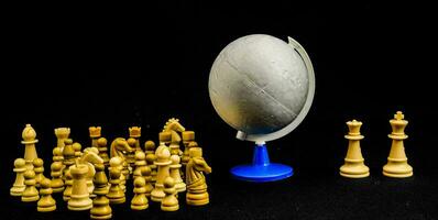 a globe, chess pieces and a chess board photo