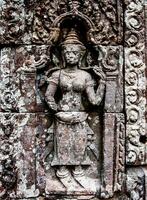 a stone carving of a woman on the wall of an ancient building photo