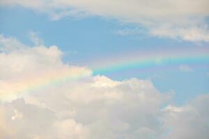 Beautiful rainbow with clouds and blue sky photo