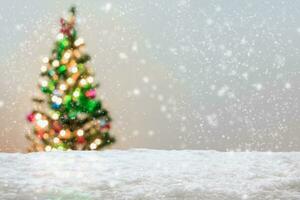 Empty white snow with blur Christmas tree with bokeh light background photo