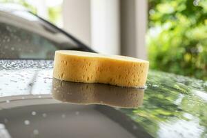 coche limpieza y Lavado con amarillo esponja y espuma jabón foto