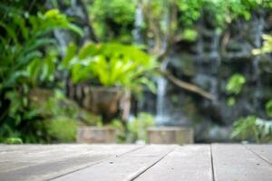 Empty wood table top with blur green tropical garden background for product display photo