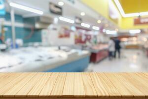 Empty wood table top with supermarket blurred background for product display photo