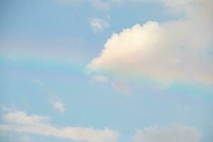 Beautiful rainbow with clouds and blue sky photo