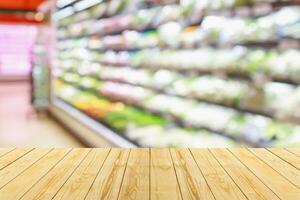 Empty wood table top with supermarket blurred background for product display photo