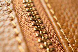 close up of zipper on brown leather bag photo