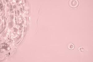 Abstract transparent water shadow surface texture natural ripple on pink background photo