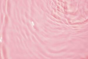 Abstract transparent water shadow surface texture natural ripple on pink background photo