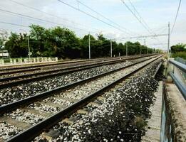 a train track with gravel and power lines photo