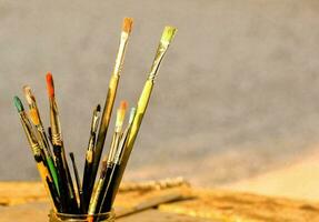 a glass jar filled with paint brushes photo