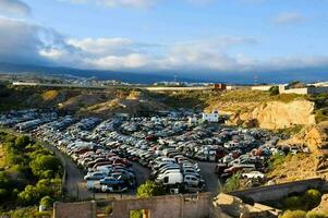 cars parked in a parking lot near a mountain photo