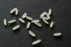 Close up of uncooked rice grains on black background. Healthy food concept. photo