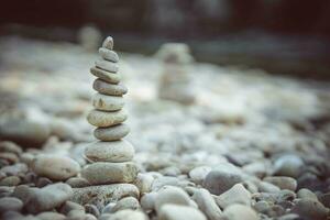 pirámide de piedras en el río banco. zen zen concepto. foto