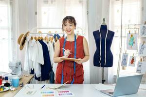 Portrait of Asian fashionable freelance dressmaker in her artistic workshop studio for fashion design and clothing business industry concept photo