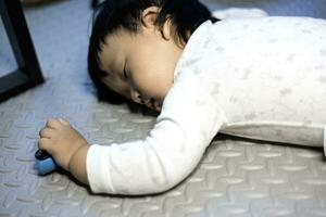 Baby Boy Sleeping On Floor With Toy In His Hand. photo