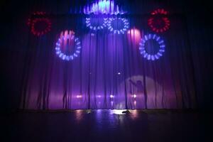 Theatrical stage. Stage curtain with beams of a spotlight and a shadow of a man. photo