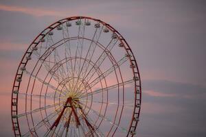 Retro ferris wheel carousel on the background of the evening sky. photo