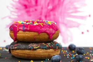 creativo dulce alimento. brillante rosquillas con multicolor asperja en un vistoso antecedentes. foto