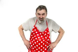 An elderly bearded man in a red polka-dot culinary apron on a white background. photo