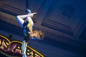 el niña realiza acrobático números en el lienzos un pequeño circo artista realiza en el lienzos de acróbatas. niño realizar acrobático elementos en el aire foto