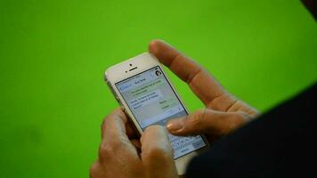 människor skrivning i mobil telefon med grön eller krom bakgrund. video