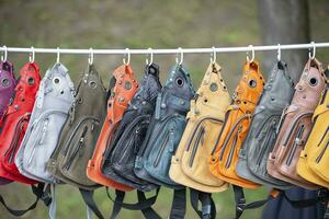 Leather multi-colored backpack bags are sold at the fair. photo