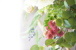 A branch with an artificial prickly flower on a light background. photo