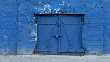 Closed old blue door in a brick wall. photo