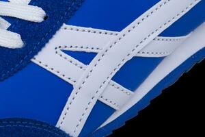 A fragment of a blue sneaker close up. Sneaker texture photo