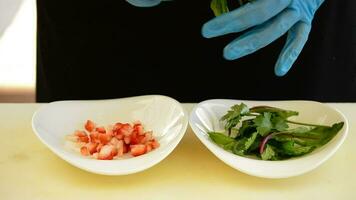 Hands of professional chef adding seasoning and strawberry with cilantro oil video