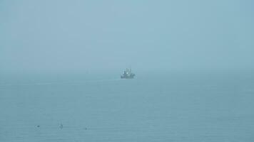 The peaceful sea view with the fishing boat sailing on it in the cloudy day photo