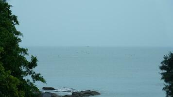 The peaceful sea view with the fishing boat sailing on it in the cloudy day photo