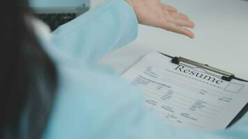 Hands of recruiter holding resume in front of candidate at desk video