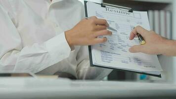 Hands of recruiter holding resume in front of candidate at desk video