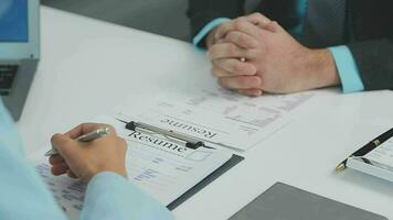 Hands of recruiter holding resume in front of candidate at desk video