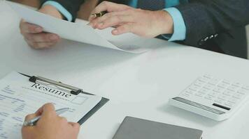 Hands of recruiter holding resume in front of candidate at desk video