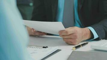 Hands of recruiter holding resume in front of candidate at desk video